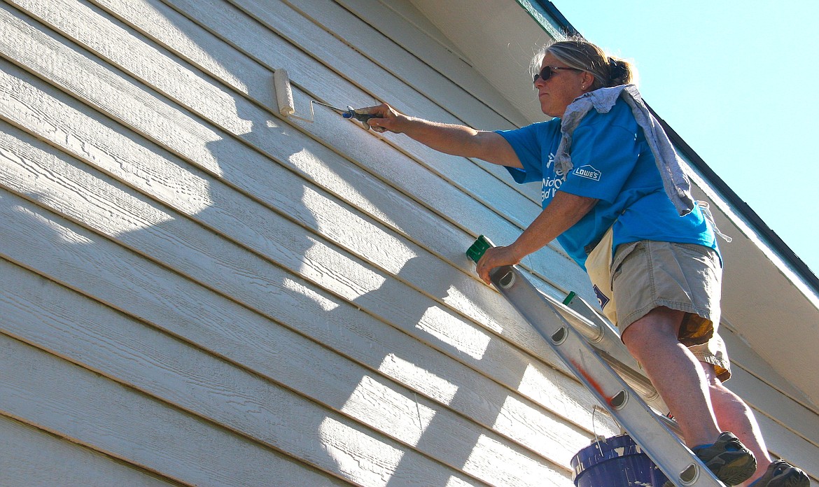 Volunteer Lori Heimbigner paints Nathan Smalley's future home 
in Post Falls on Tuesday morning during the 11th annual National Women Build 
Week organized by Habitat for Humanity and Lowe's. (BRIAN WALKER/Press)
