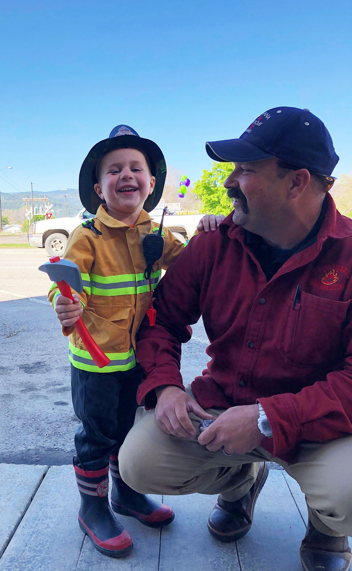 Jace Russell was in full gear including radio, and safety helmet while he helped dad Plains-Paradise Fire Chief James Russell at the Franklin Vincent Reed Junior Fire Fighter Scholarship Fund-Fundraiser on Saturday (Erin Jusseaume/ Clark Fork Valley Press)