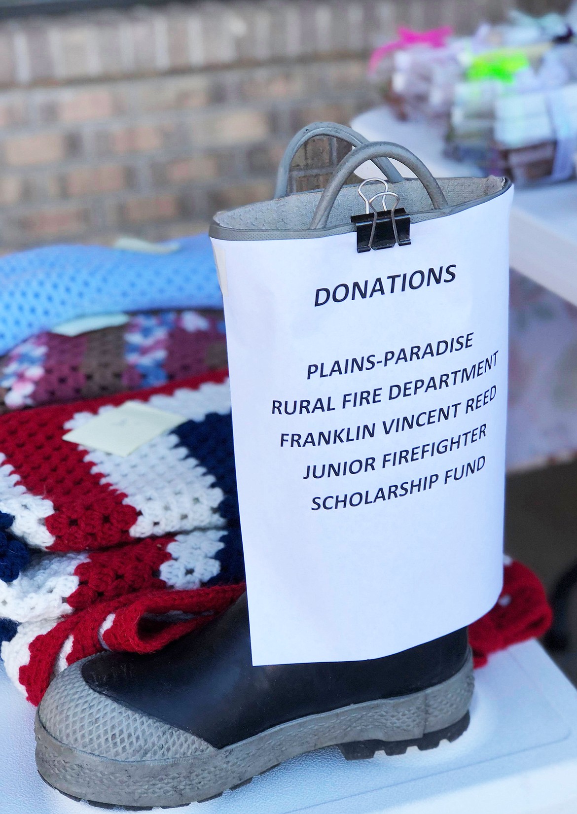 A boot to collect some spare change for donations was set up next to the table front and center (Erin Jusseaume/ Clark Fork Valley Press)