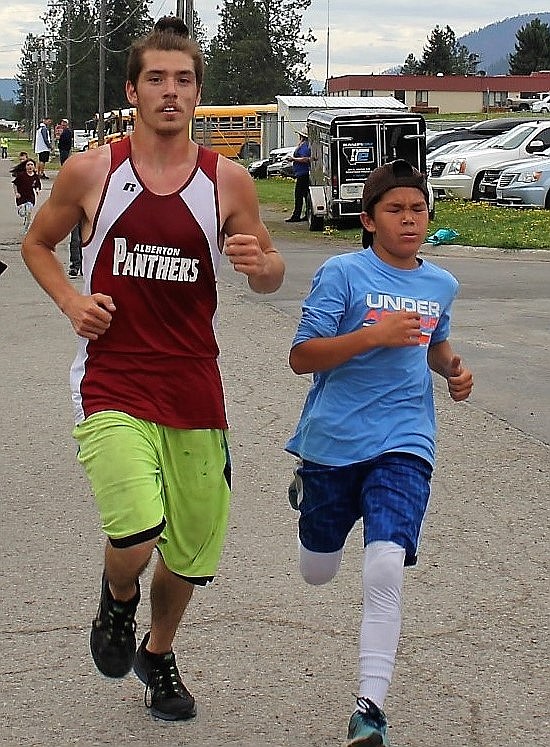 Superior 6th grader, Lucas Kovalsky crosses the finish line with Alberton track athlete, Jesse Shaske during the 5K race at the Mineral County Fun Run.