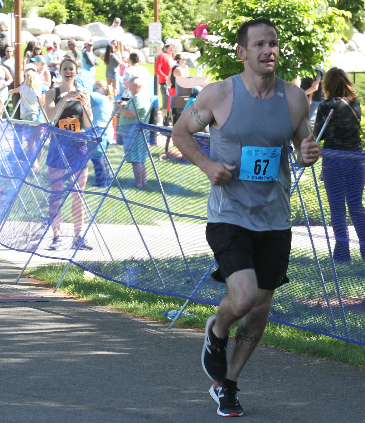 JASON ELLIOTT/Press
Joe Hewitt crosses the finish line to win Sunday&#146;s Coeur d&#146;Alene Marathon in 3 hours, 2 minutes and 7.8 seconds. Pictured in the back is Hewitt&#146;s wife, Chelsea, who competed in the half-marathon event on Sunday.