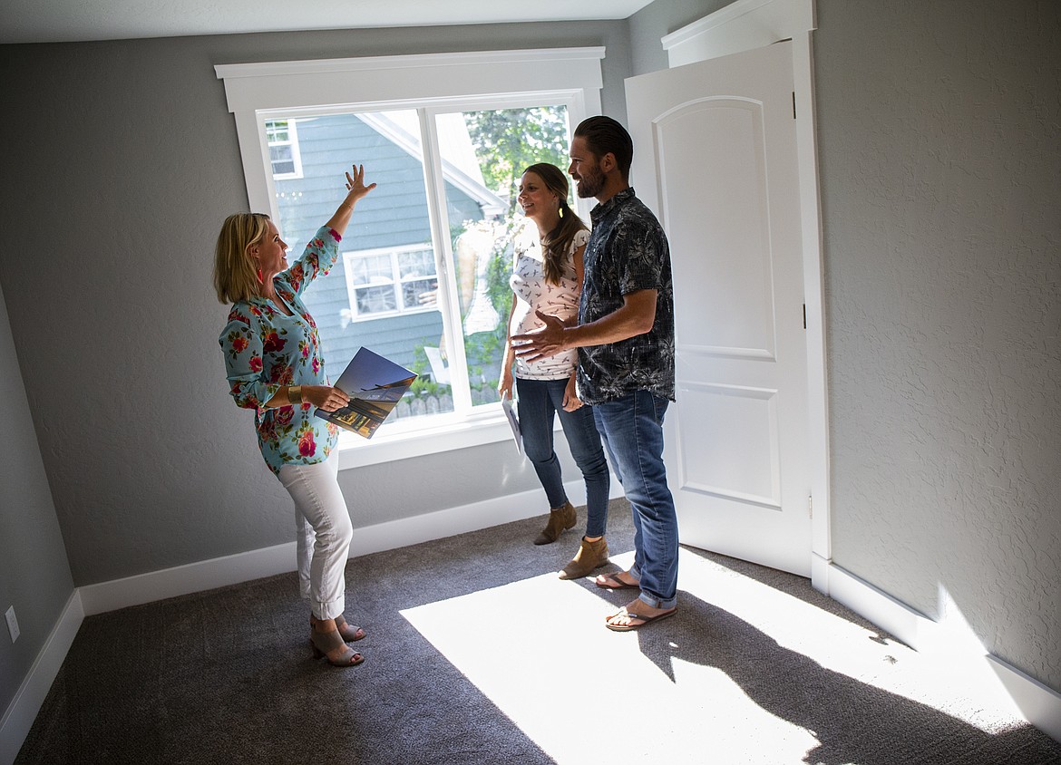 Coldwell Banker Schneidmiller Realty agent Gretchen Vedel show off a bedroom to Coeur d'Alene couple Riley and Kelly Cooney Monday afternoon in downtown Coeur d'Alene. (LOREN BENOIT/Press)