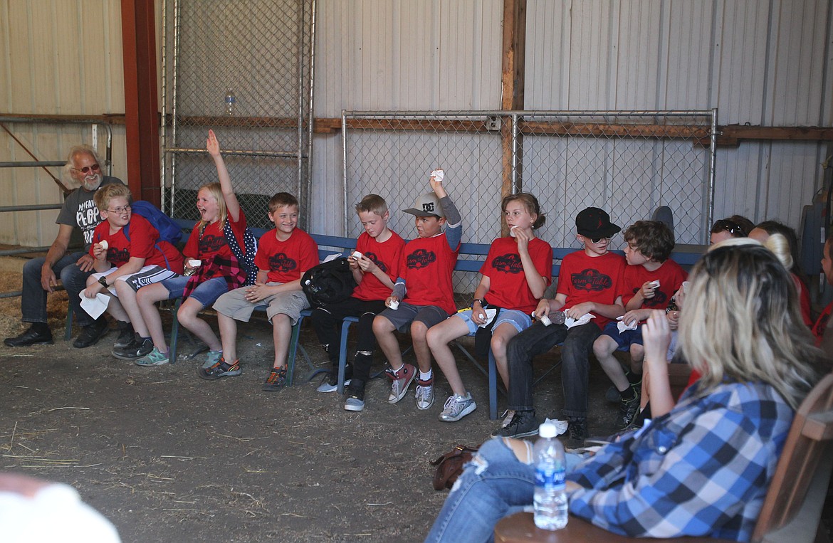 Arms shoot into the air Thursday as Carol Parrott's fifth-grade class from Betty Kiefer Elementary School answers whether brown cows produce chocolate milk during the Farm to Table day at the Kootenai County Fairgrounds. Answer: No, they don't. (DEVIN WEEKS/Press)