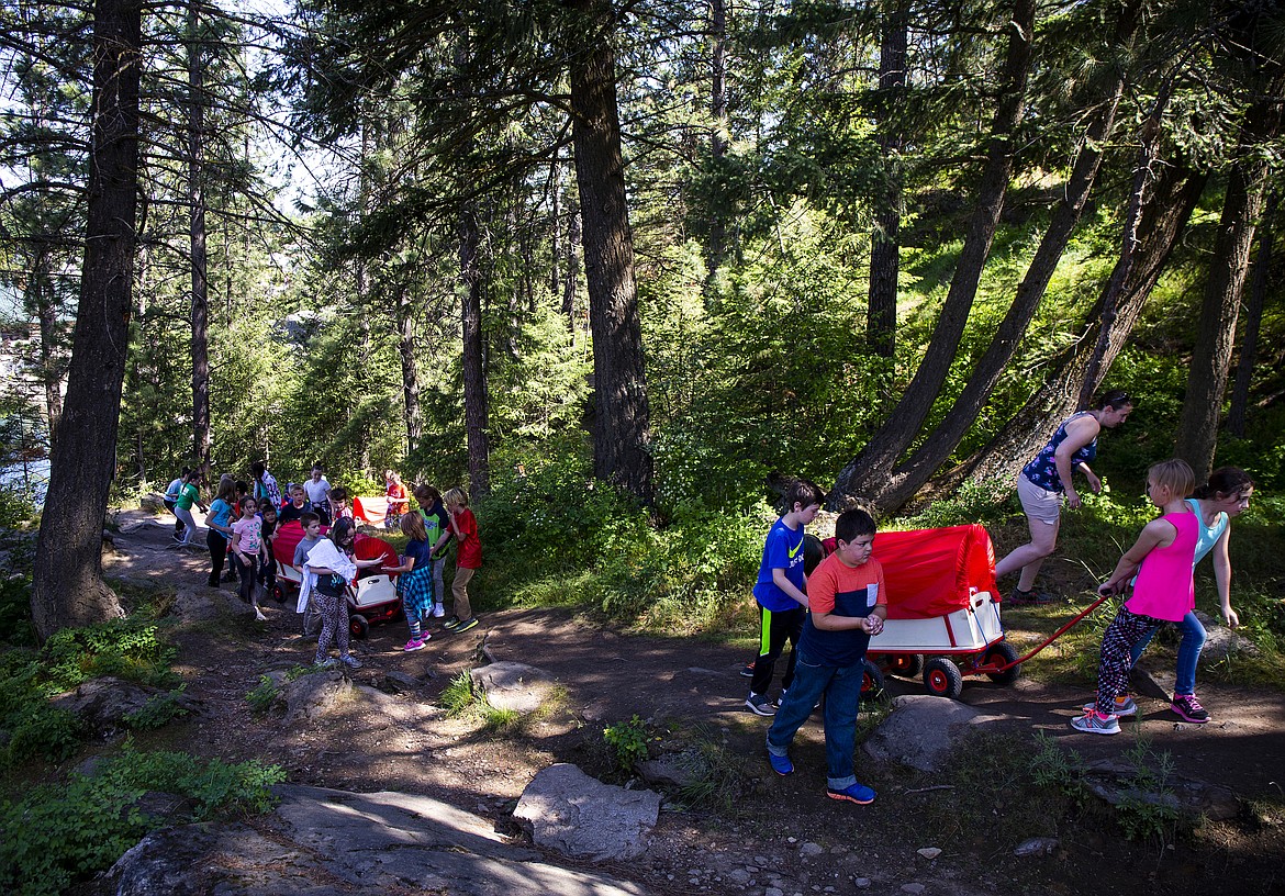 Students from Borah Elementary pull their wagons up Tubbs Hill Wednesday morning as part of their studies of Northwest history.