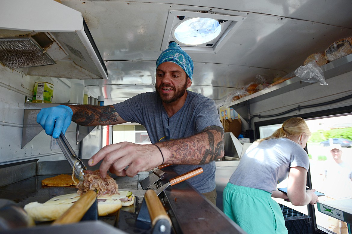 Tony Traina and Kayleigh Kasper work inside the Fork in the Road food truck in Kalispell on Saturday, May 19. (Casey Kreider/Daily Inter Lake)