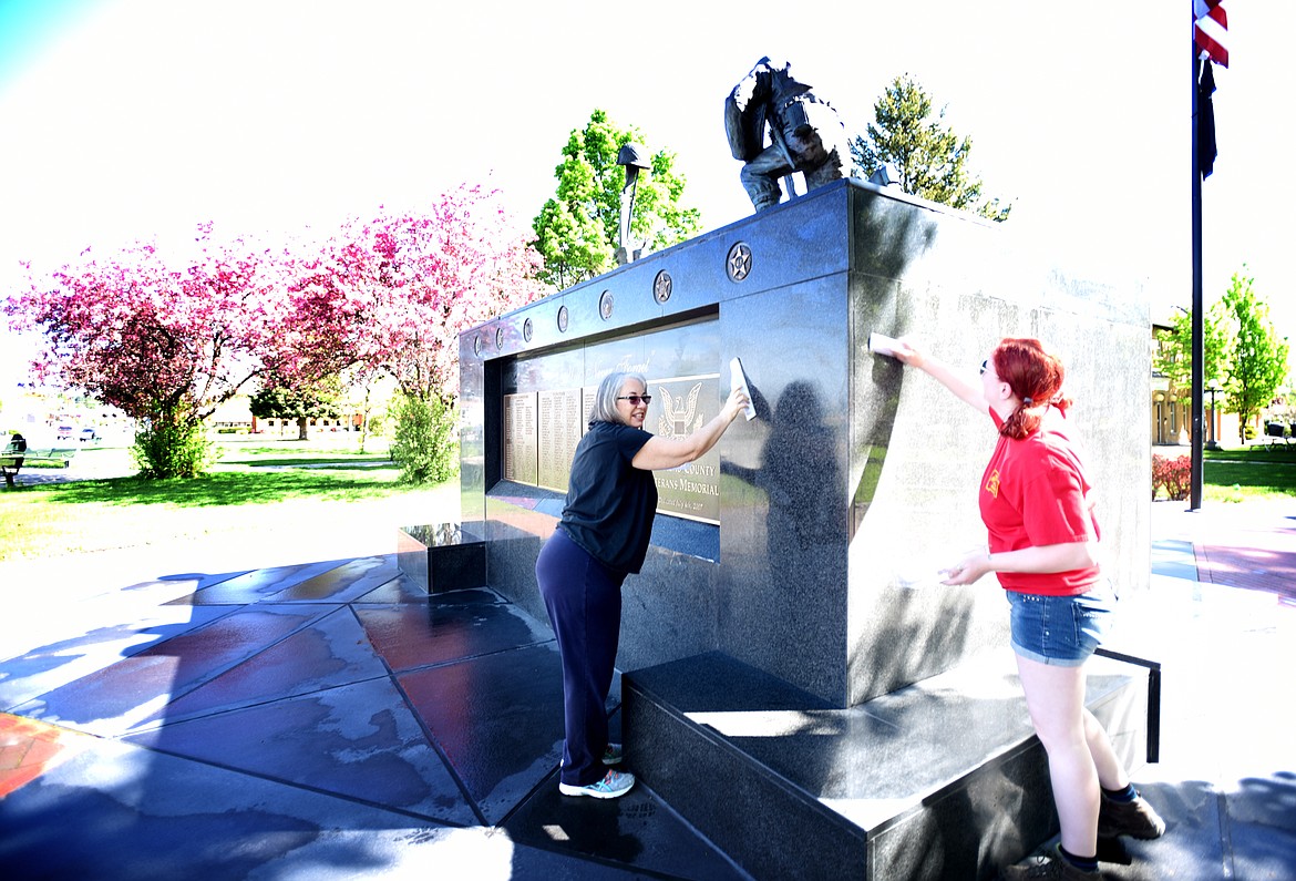 Terry Kaylor, left, and Cristina Woolley help clean and polish the memorial.