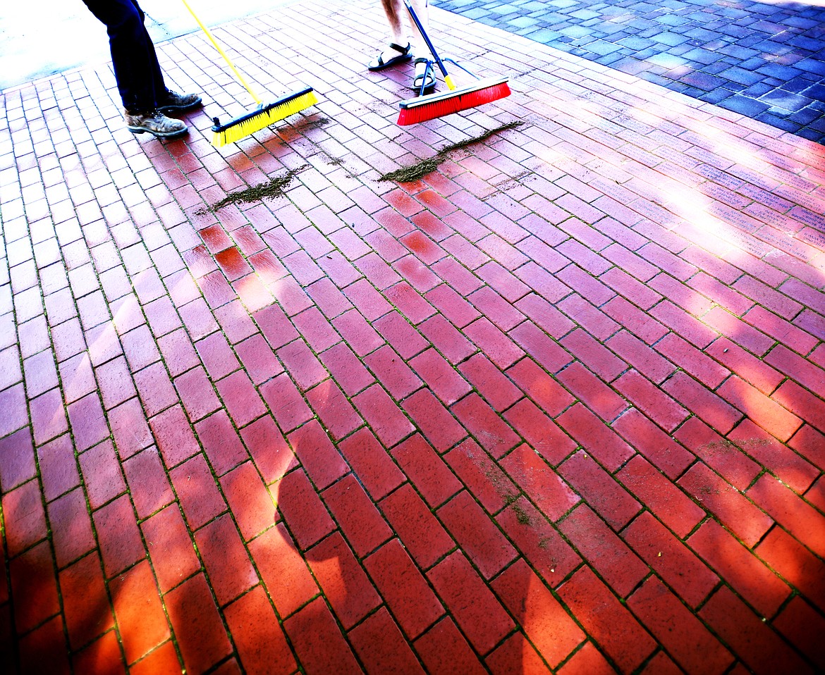 Sand is poured over bricks and swept into place to secure them. The bricks have been left loose so future donors can continue to purchase inscribed bricks. To support the monument or buy a brick visit&#160;www.flatheadveteransmemorial.com.