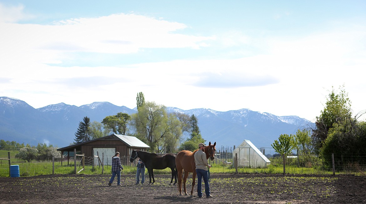 Natalie Norrell instructs XXXX while Jim Vincent works with Molly during a joint horse therapy session Saturday morning. (Mackenzie Reiss/Daily Inter Lake)