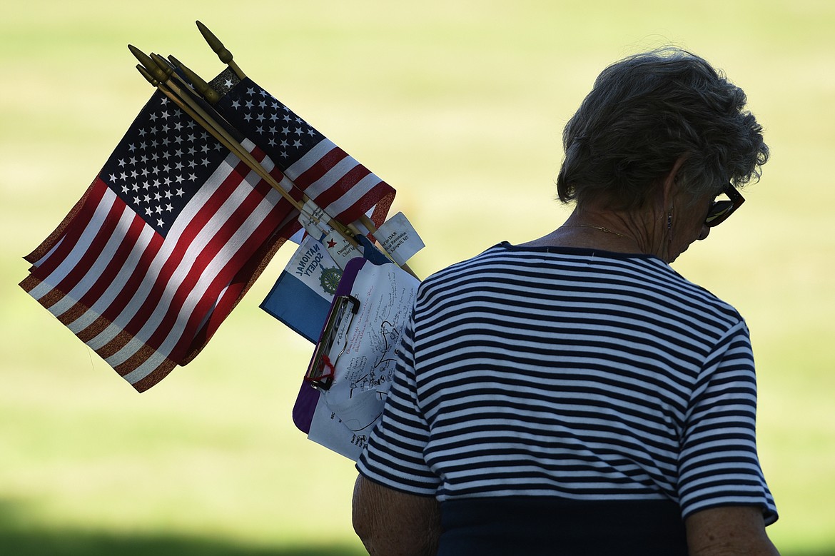 Barb Alsbury, a member of the Chief Ignace Chapter of the National Society Daughters of the American Revolution, searches for gravestones of past members in Conrad Memorial Cemetery in Kalispell on Friday morning. (Casey Kreider/Daily Inter Lake)