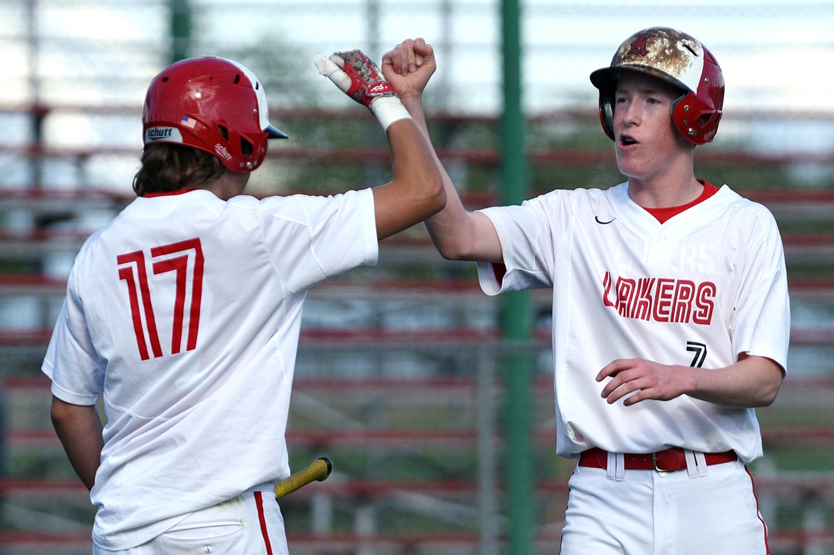 Kalispell Lakers B Aidan Smith (17) congratulates Jack Corriveau (7) after scoring a first-inning run against Libby at Griffin Field in Kalispell on Tuesday. (Casey Kreider/Daily Inter Lake)