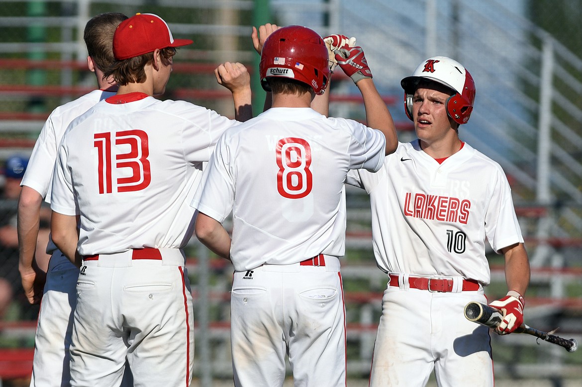 Kalispell Lakers B AJ Wood (10) is congratulated by teammates Jack Corriveau (7), Ethan Diede (13) and Tanner Leonetti (8) after scoring a run in the bottom of the third against Libby at Griffin Field on Tuesday. (Casey Kreider/Daily Inter Lake)