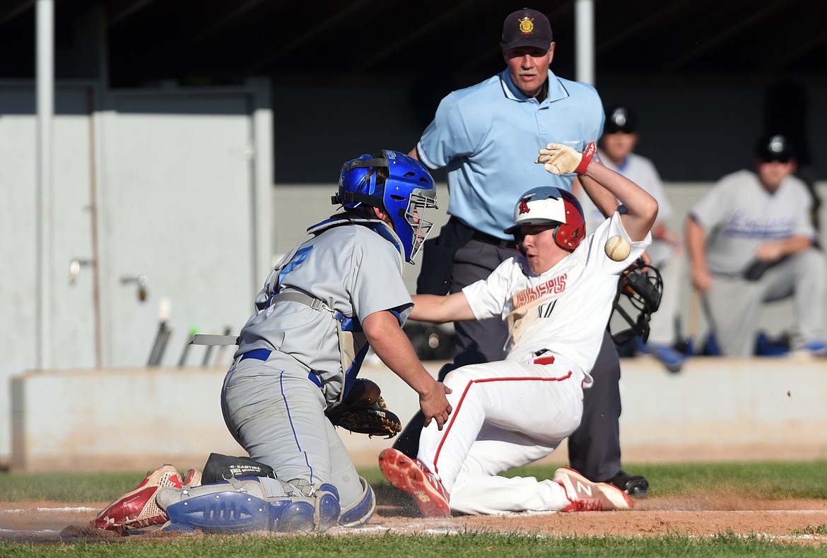 Kalispell Lakers B Aidan Smith slides safely into home in the bottom of the third as Libby catcher Quade Anderson can't handle the throw. (Casey Kreider/Daily Inter Lake)