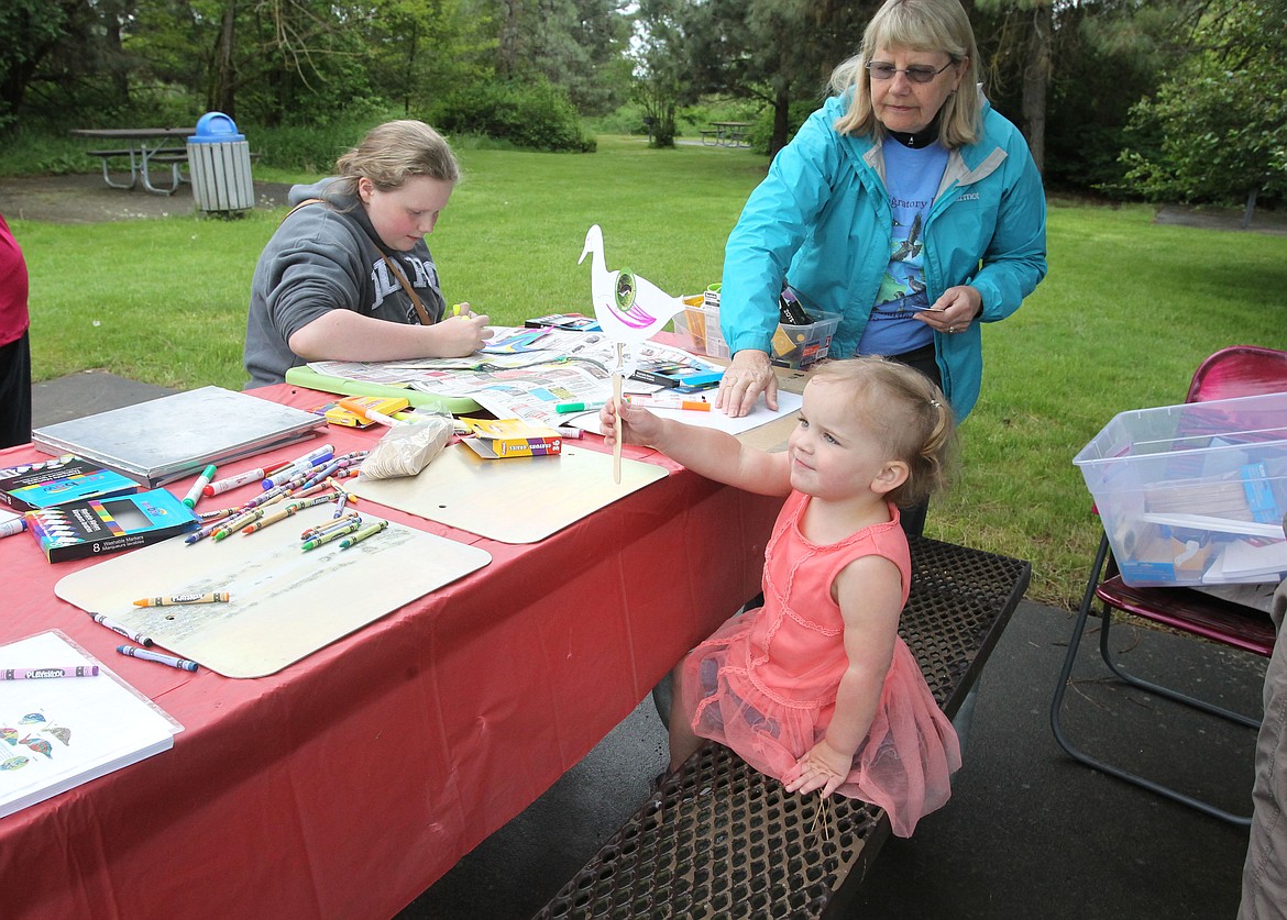 Ayvah Locke, 3, of Post Falls, shows off a paper duck she colored at an art station during Migratory Bird Day at the Idaho Bureau of Land Management's Blackwell Island recreation site Saturday morning. More than 10 activity stations invited kids and adults alike to learn more about the birds in their own back yard and how to protect them. (DEVIN WEEKS/Press)
