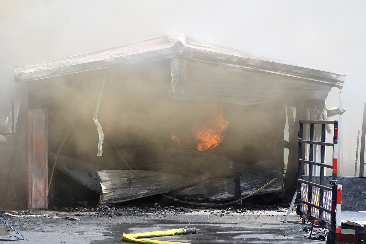 Smoke and fire pour out of the garage where it is believed the fire began.