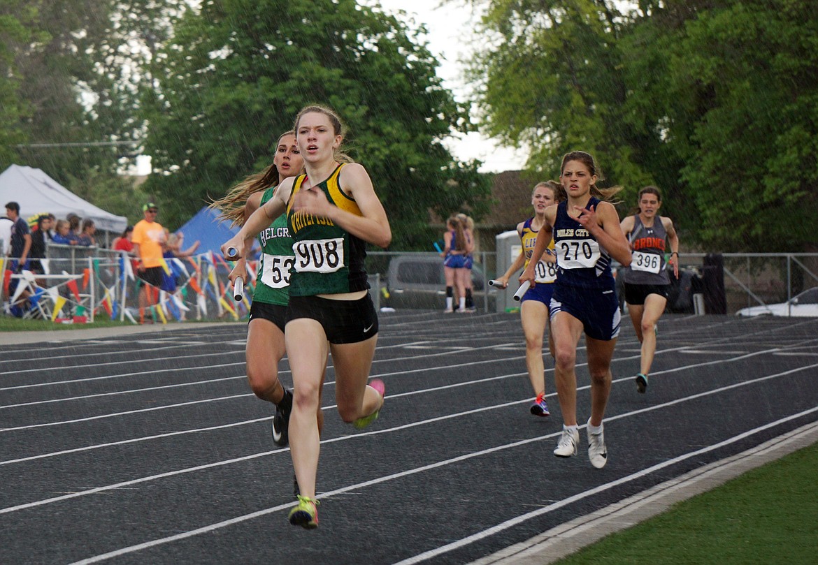 As rain begins to fall Lauren Schultz runs a leg of 4x400 at the Class A state track meet in Laurel last weekend. (Photo courtesy Matt Weller)