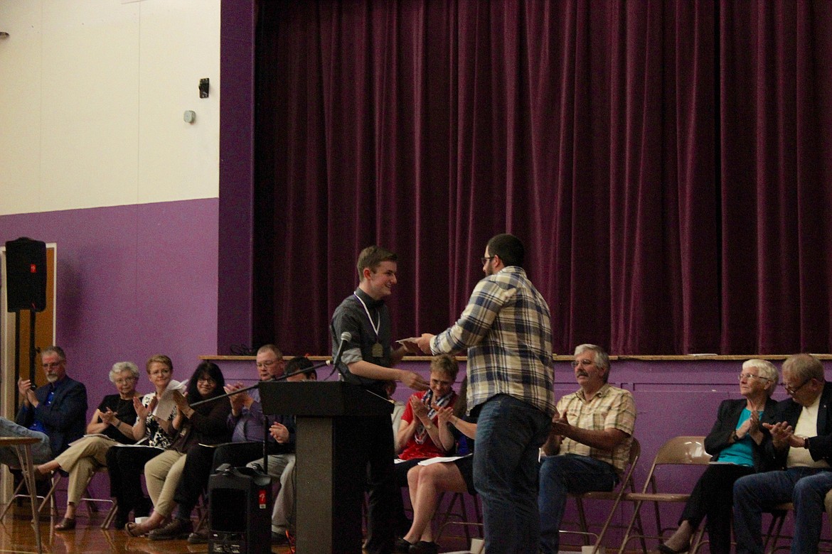 Photo by LILA HILEMAN/ Terran Dykes receives a scholarship from PE/Health Teacher Stetson Spooner.