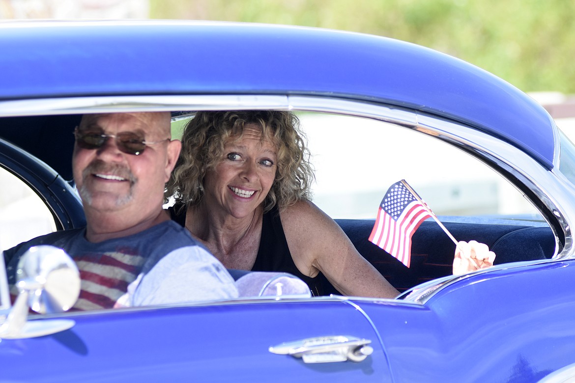 Participants in the Memorial Day parade Monday smile while riding down Second Street. (Heidi Desch/Whitefish Pilot)