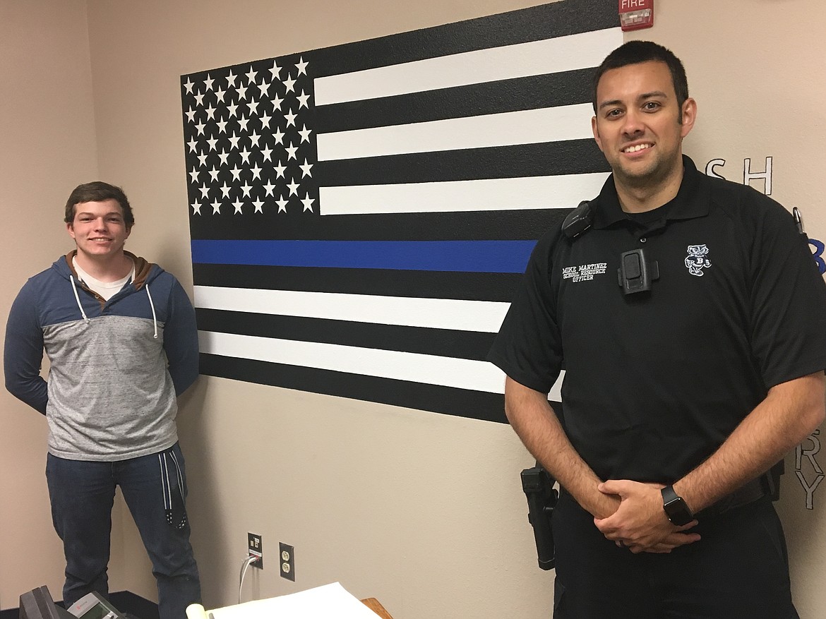 Photo by TED LUDLUM
Bonners Ferry High School Junior Jesse Bradley (left) and school resource officer Mike Martinez stand next to a mural titled, &#147;The Thin Blue Line&#148; that he painted on the wall of Martinez&#146;s high school office as a project for his art class.