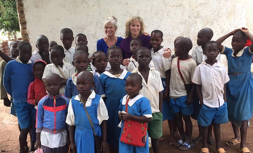 Children flock to Linda Hagen Miller, center left, and Chrisdee Imthurn during their September 2017 trip to Kenya where they worked with Partnering for Progress, a nonprofit that helps improve the quality of life of the people of the Kopanga region. (Courtesy photo)