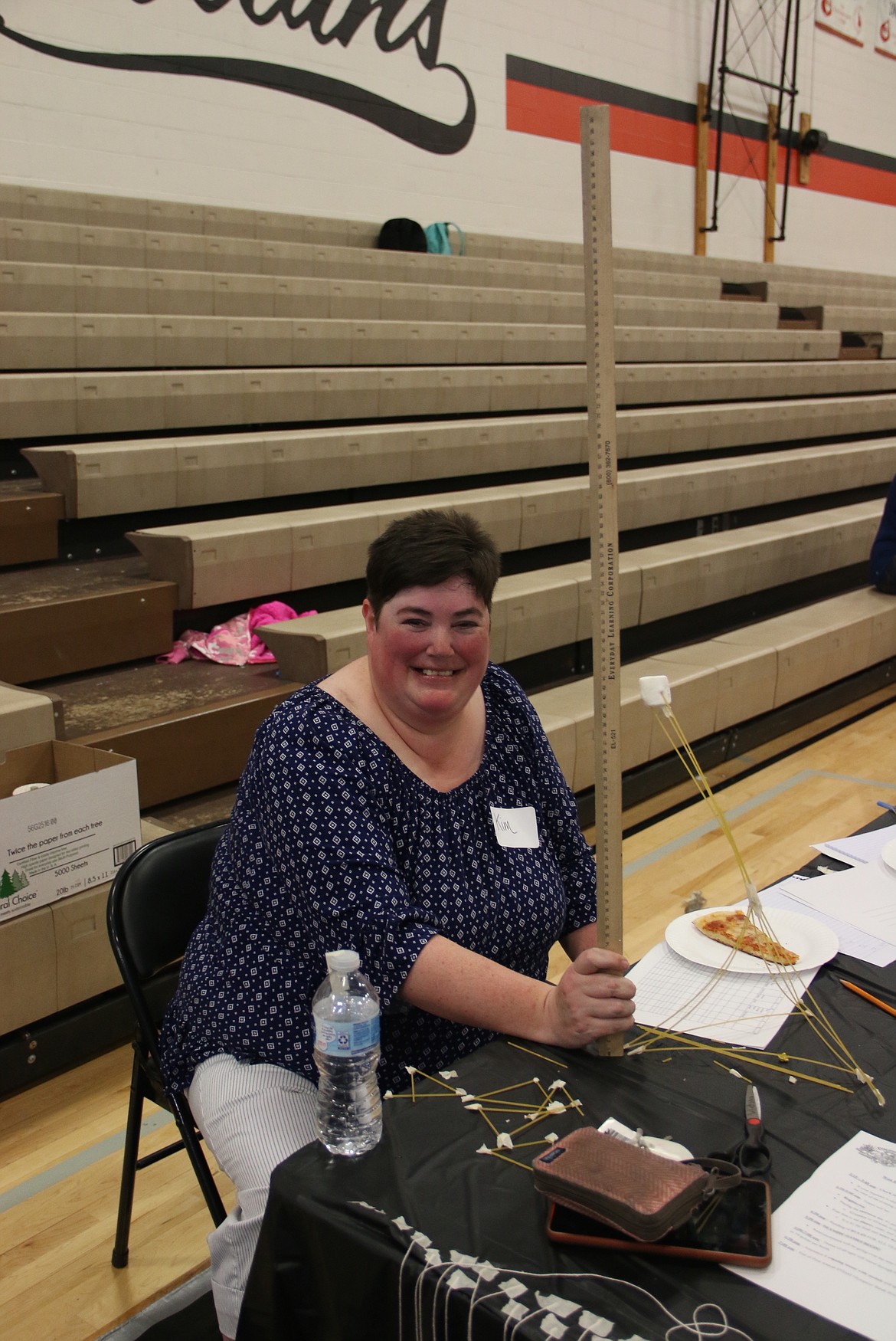 (Photo by MARY MALONE)
Kim Proctor, who ran the table for the STEaM Olympics marshmallow challenge on May 23, measures her own tower. The challenge consisted of STEaM Olympics competitors earning points by trying to build the tallest free-standing tower of spaghetti noodles that will stay upright when the marshmallow is placed on top.