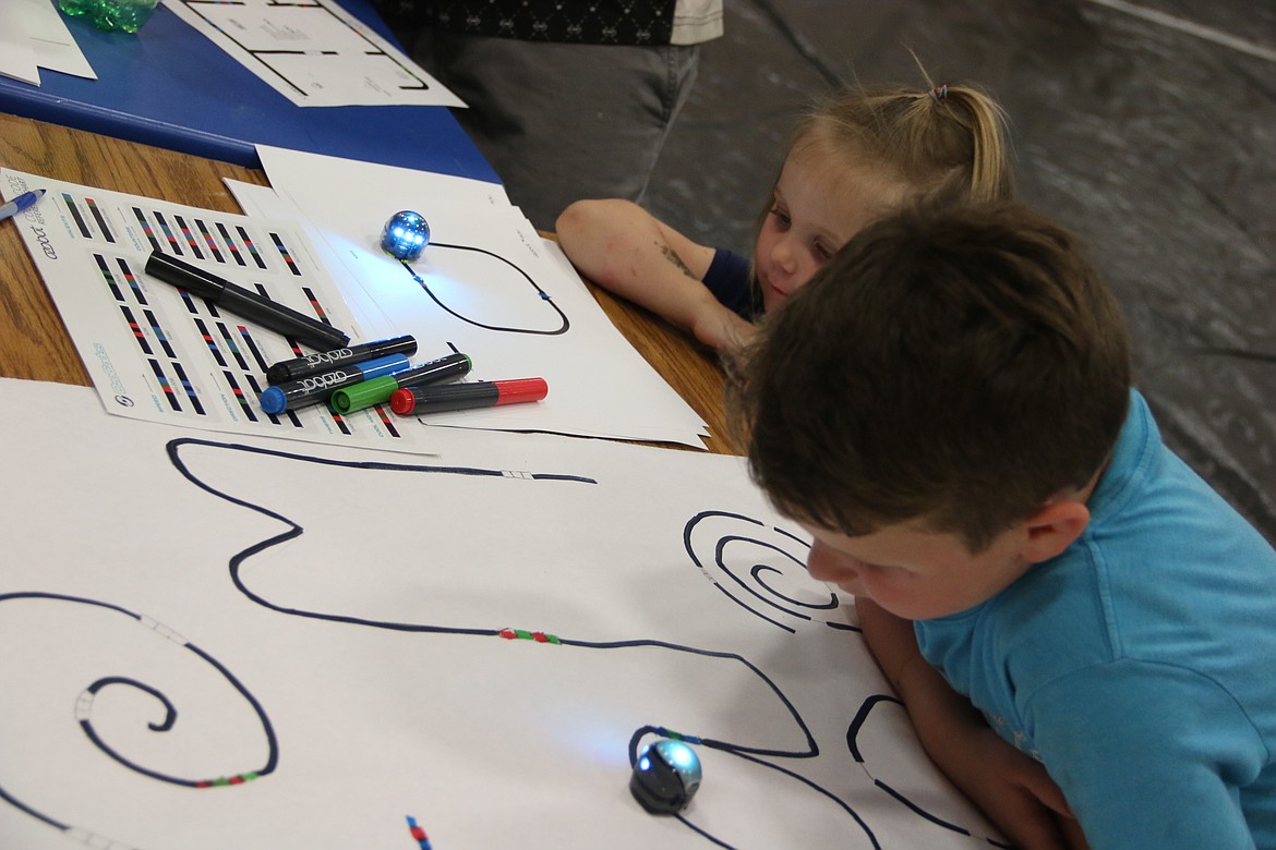 (Photo by MARY MALONE)A couple of young competitors watch the color-changing ozobots during the STEaM Olympics held at Priest River Lamanna High School on May 23.