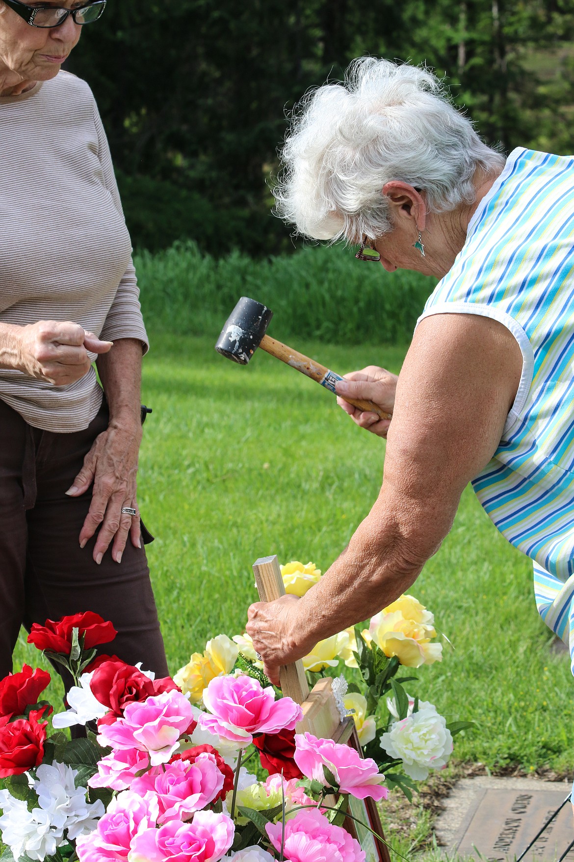 Photo by MANDI BATEMAN
Edwina Owens places framed photos and handmade wreaths for her family at Grandview Cemetery.