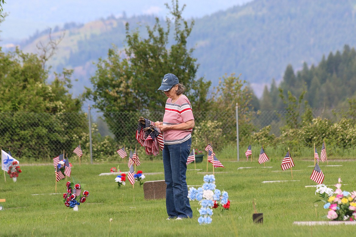 Photo by MANDI BATEMAN
Veteran Jackie Spence places flags on veteran's graves at the Grandview Cemetery.