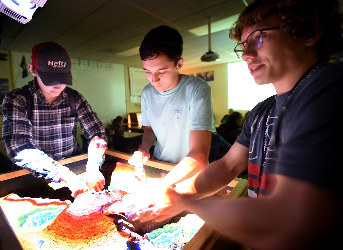 From left, sophomores Cody Bicknell, Andrew Dixon and Alexander Bertrand work with an augmented reality sandbox on May 17 at Glacier High School. (Brenda Ahearn/Daily Inter Lake)