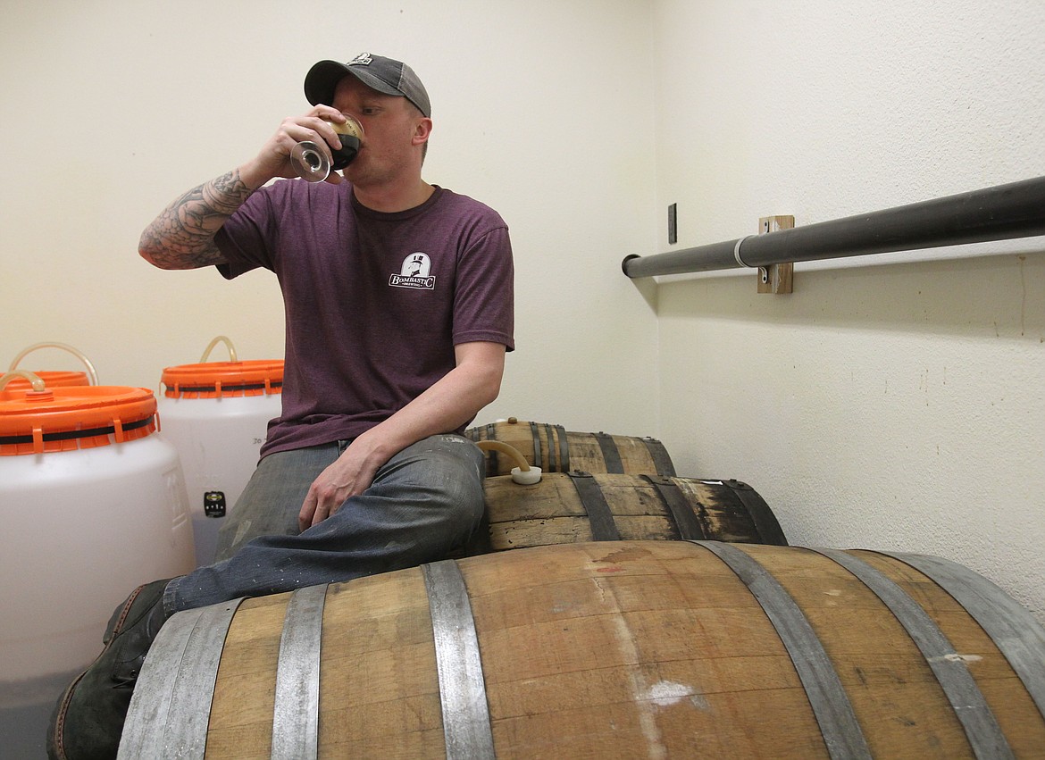 Photos by DEVIN WEEKS/NIBJ
Bombastic Brewing co-owner and co-founder Phil Hottenstein samples a Bombastic brew atop bourbon barrels in a back room of the Bombastic production facility in late March. Hottenstein and his partners are working toward building community among local brewers to help usher in a vibrant craft beer scene in North Idaho.