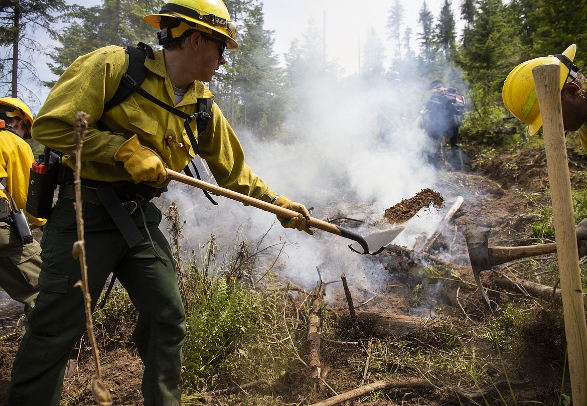Cole Fawcett tosses dirt on a fire during a training exercise Thursday afternoon south of Coeur d'Alene up Cougar Gulch.  The training, hosted by North Idaho Wildfire Training Zone, is designed to train new firefighters in managing and suppressing wildfires. (LOREN BENOIT/Press)