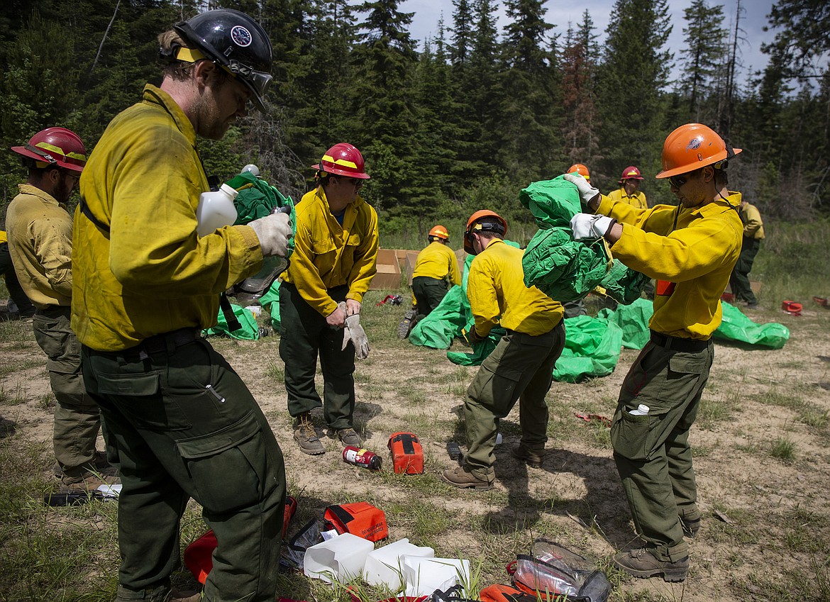 Firefighters unpack fire shelters during a fire entrapment training exercise Thursday afternoon up Cougar Gulch. (LOREN BENOIT/Press)