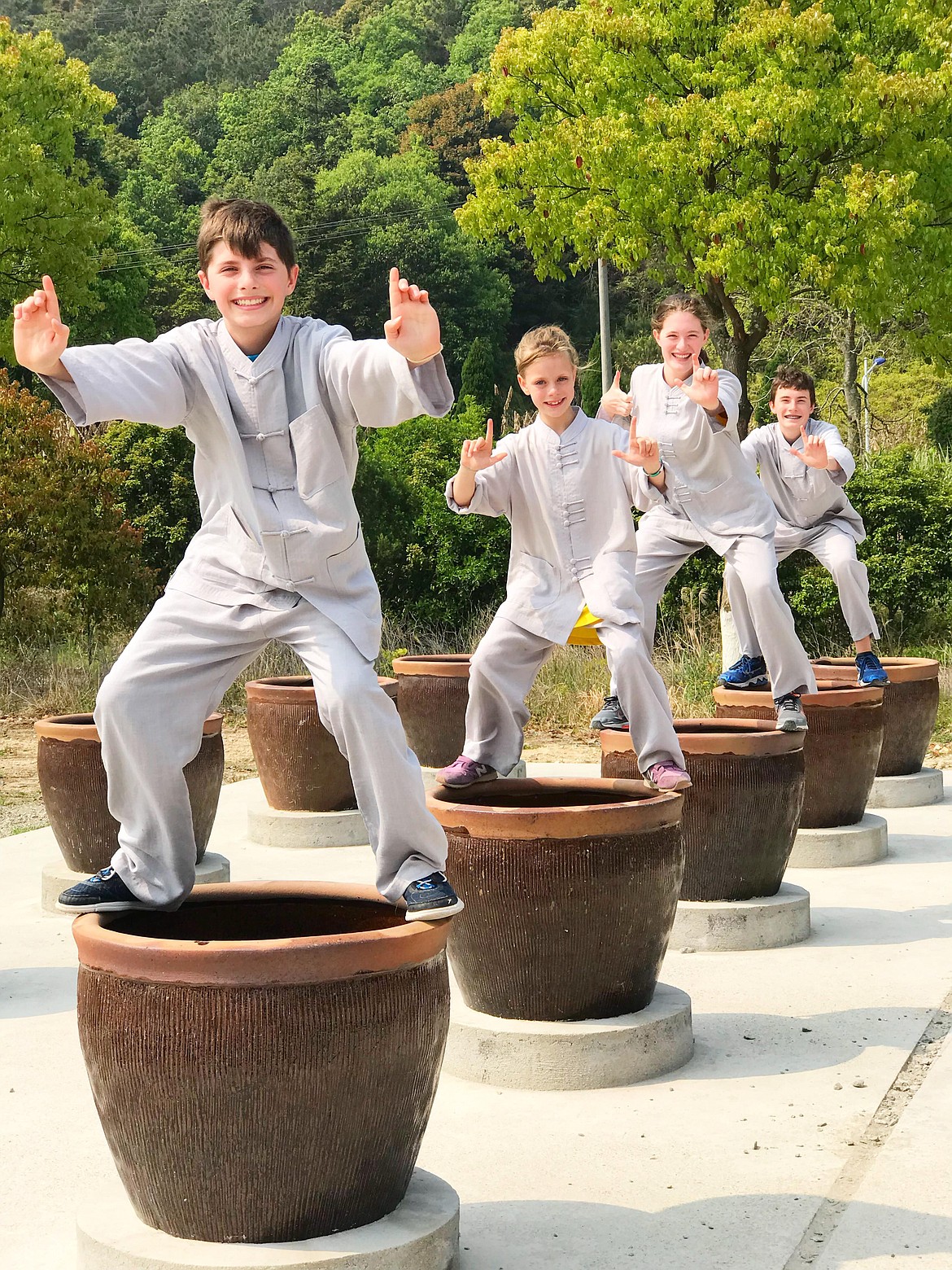 From left, Ford kids Hudson, 12, Mara, 8, Emma, 15 and and Bennett, 14, pose atop large pots at a hidden away mountaintop monastery in the Fujian Provence of Putian, China, during their six-month world trip earlier this year.
 &#147;We got to stay at a Buddhist monk monastery in exchange for picking tea leaves on their tea plantation and cleaning candle wax out of thousands of glass jars,&#148; Emma wrote to The Press. &#147;Giving back to earth and the Buddhist monk community and supporting the cycle of life helped me realize that the art of giving is so much more beneficial than receiving.&#148; (Courtesy photo)