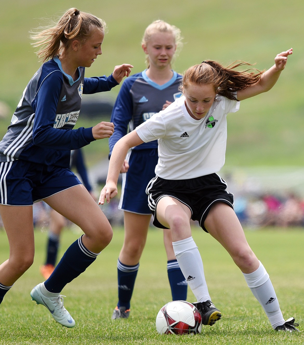 Flathead Valley United White 2003's Claire Anderson dribbles around Blitzz FC Blue 2004's Miriam Lawrence, left, and works upfield in the first half during the Montana State Cup at Kidsports Complex on Saturday. (Casey Kreider/Daily Inter Lake)