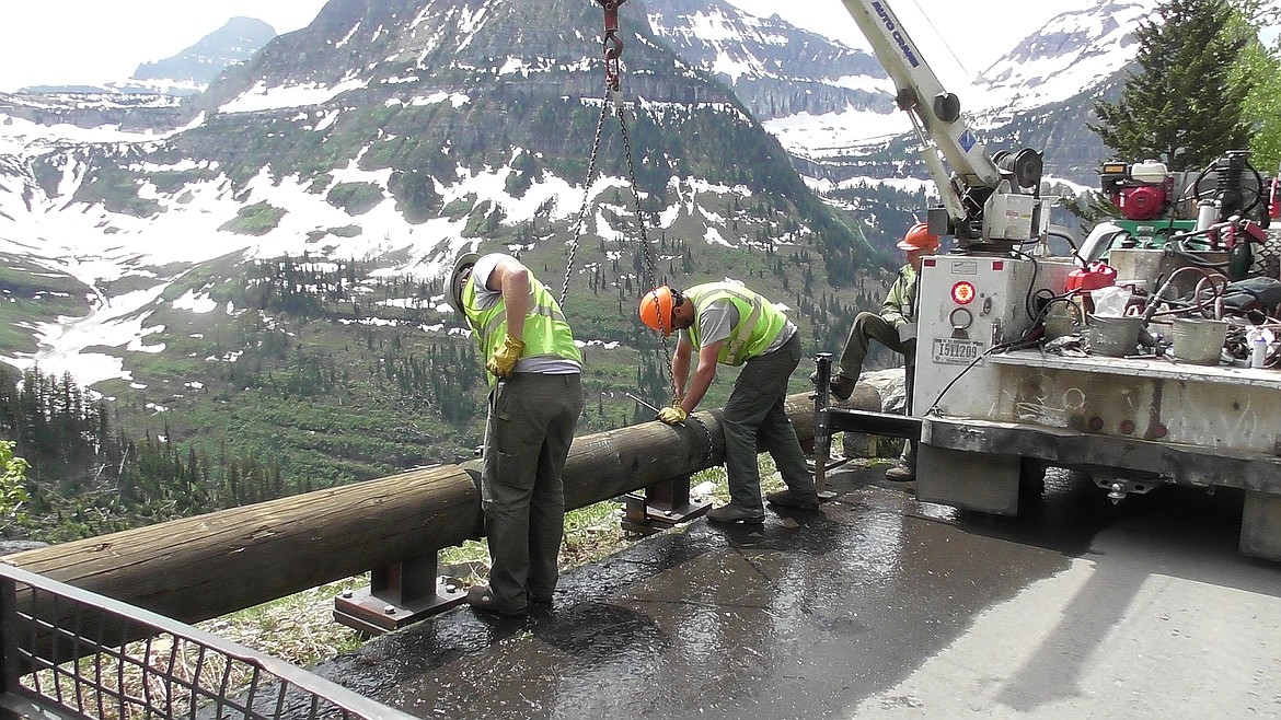 Glacier National Park seasonal workers, Chris Carpenter, left, and Jake Maule, install removable guard rails on Going-to-the-Sun Road, west of Logan Pass Thursday. (Scott Shindledecker/Daily Inter Lake)