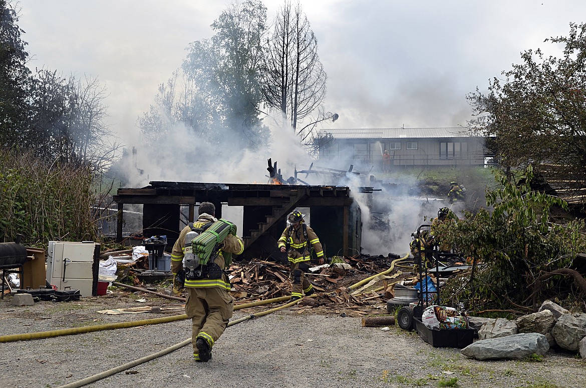 Firefighters continue to work an electrical fire that destroyed a Ramsay Avenue house Thursday. The house was in the process of being demolished. (Heidi Desch/Whitefish Pilot)