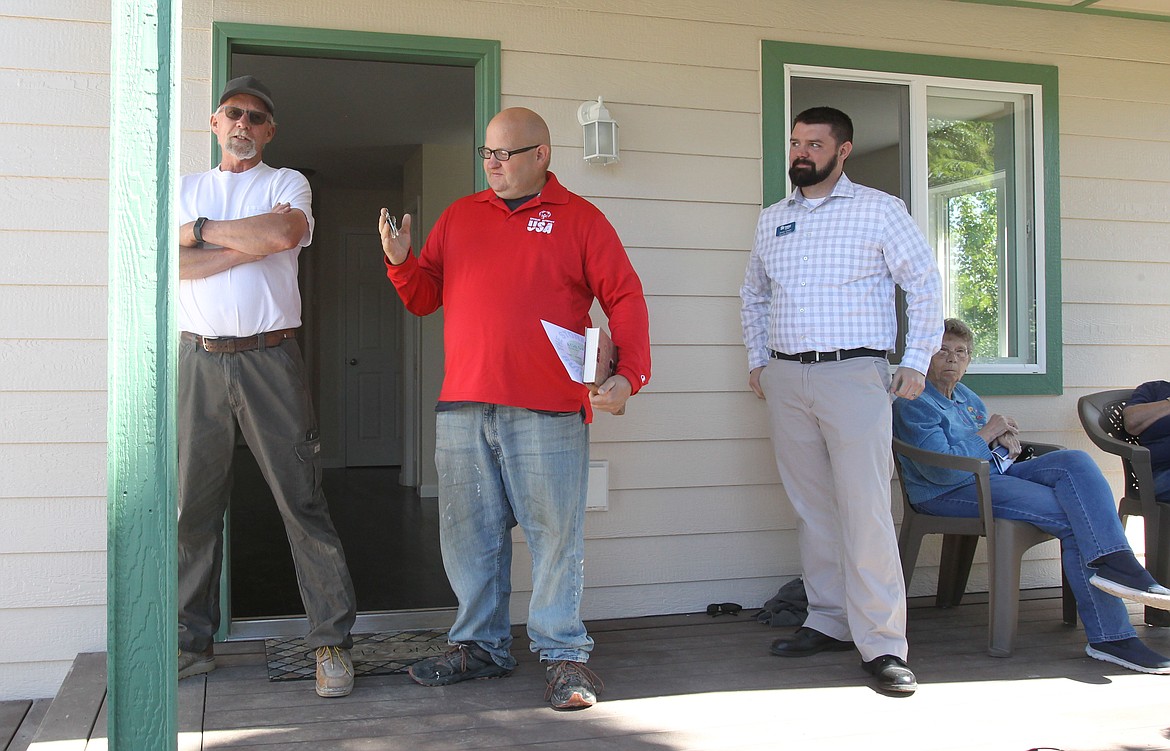 New homeowner Nathan Smalley grins after receiving the keys to his home from construction supervisor Greg Nowak, left, during the home's dedication ceremony Saturday morning. The Habitat for Humanity house is a dream come true for Special Olympics medalist Smalley, 39, who worked with Habitat executive director James Casper, right, and many other people for more than two years to reach his goal of owning a home. (DEVIN WEEKS/Press)