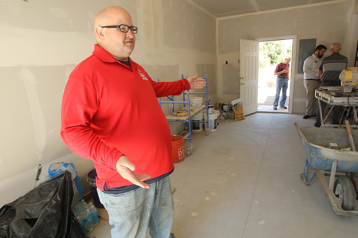 Special Olympian Nathan Smalley, who earned gold and silver medals in skiing during the World Winter Games in Austria last year, shows off his favorite part of his new home &#151; the garage &#151; Saturday during the dedication ceremony of his Habitat for Humanity house. &#147;Now I can actually work on my vehicles,&#148; he said with a smile. &#147;This here is the reason I got the house.&#148;