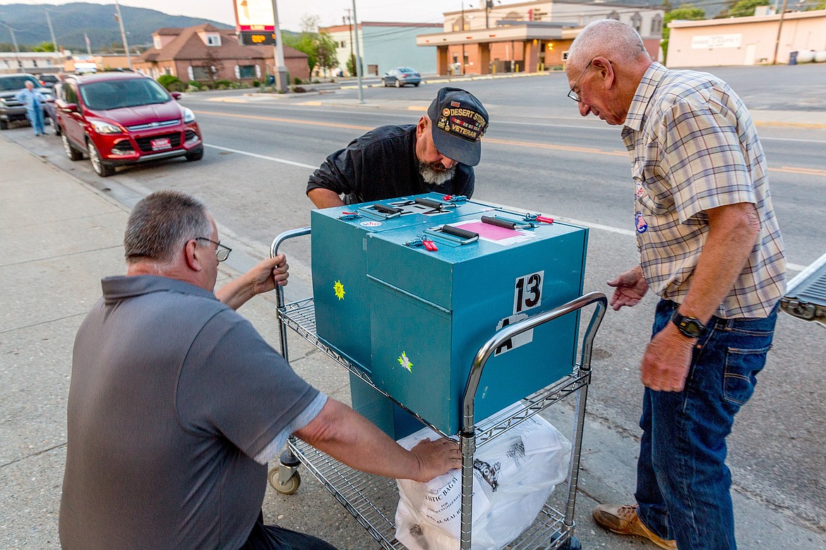 Ernie Anderson, left, Rocky Gifford and Jim Mari offload ballot boxes in front of Lincoln County Courthouse Tuesday, June 5. (John Blodgett/The Western News)