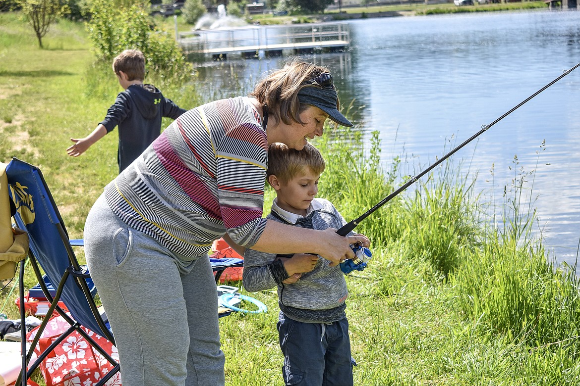 Leslie Fix helps her five year old son Jason, who was brand new to fishing, with casting. (Ben Kibbey/The Western News)