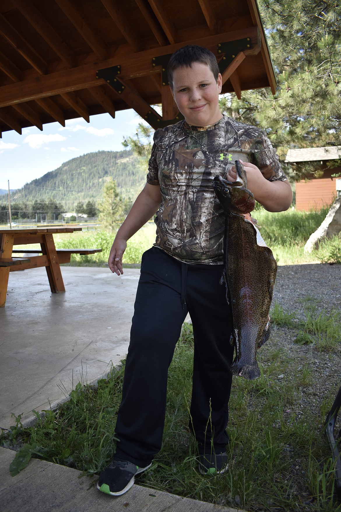 Lucas Peterson of Troy poses with the roughly 8 pound rainbow trout he caught in Roosevelt Park. (Ben Kibbey/The Western News)