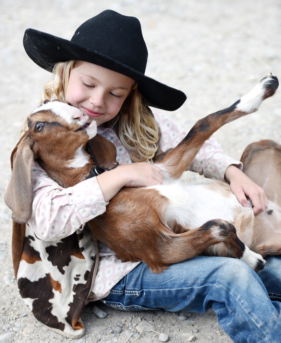 Havana Peerman, 6, playing with baby goat on Wednesday, May 23.(Brenda Ahearn/Daily Inter Lake)