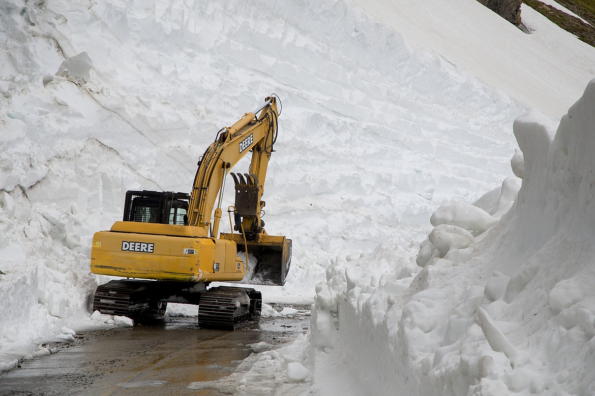 A park excavator works on a 40-foot drift on the east side of the Going to Sun Road near Logan Pass Thursday. (Jeremy Weber photo)