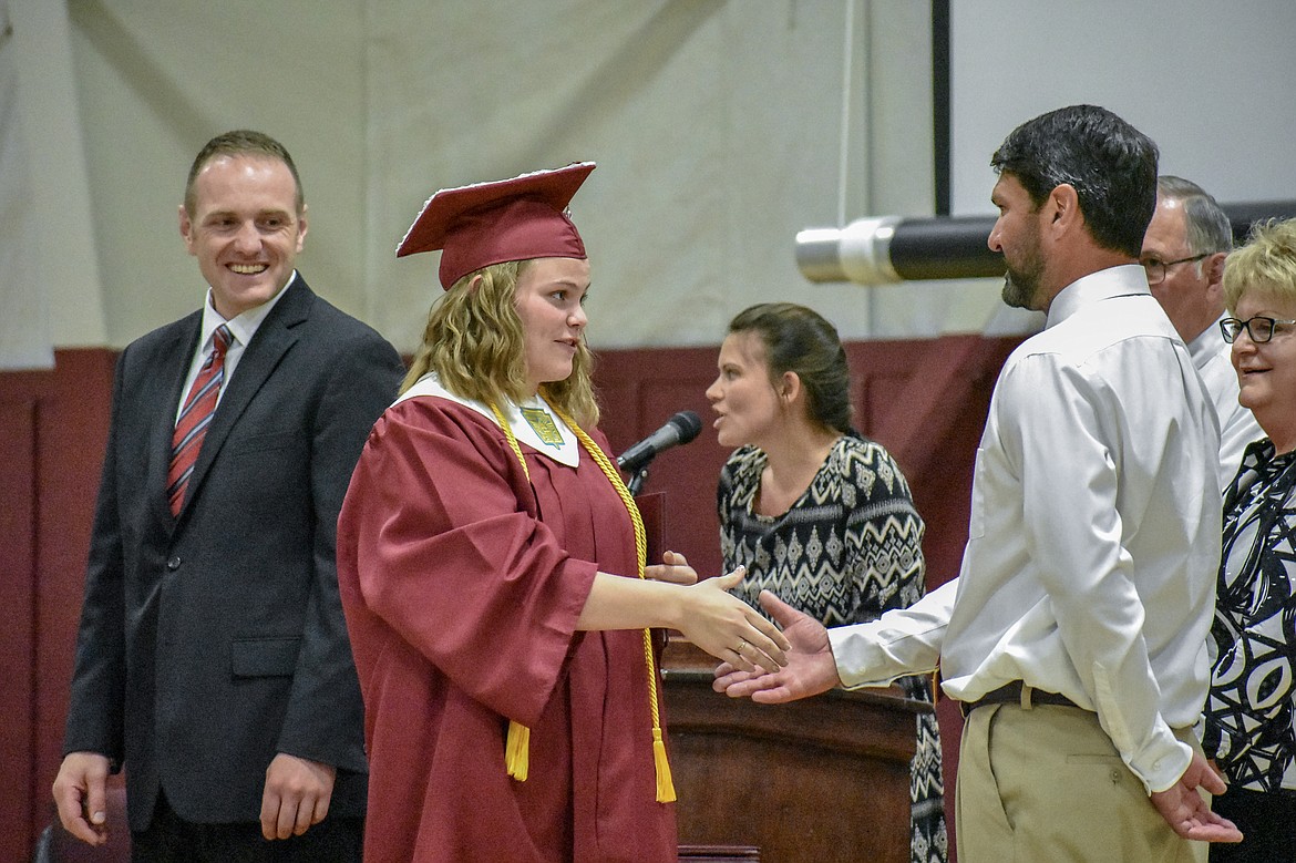 Troy's Hailey Hoban is congratulated by honorary speaker and Troy High School teacher Cory Anderson after receiving her diploma at the Troy School Activity Center auditorium for graduation on Saturday, June 2, 2018. (Ben Kibbey/The Western News)