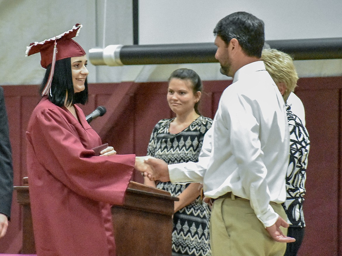Troy's MacKenzie Tallmadge is congratulated by honorary speaker and Troy High School teacher Cory Anderson after receiving her diploma at the Troy School Activity Center auditorium for graduation on Saturday, June 2, 2018. (Ben Kibbey/The Western News)