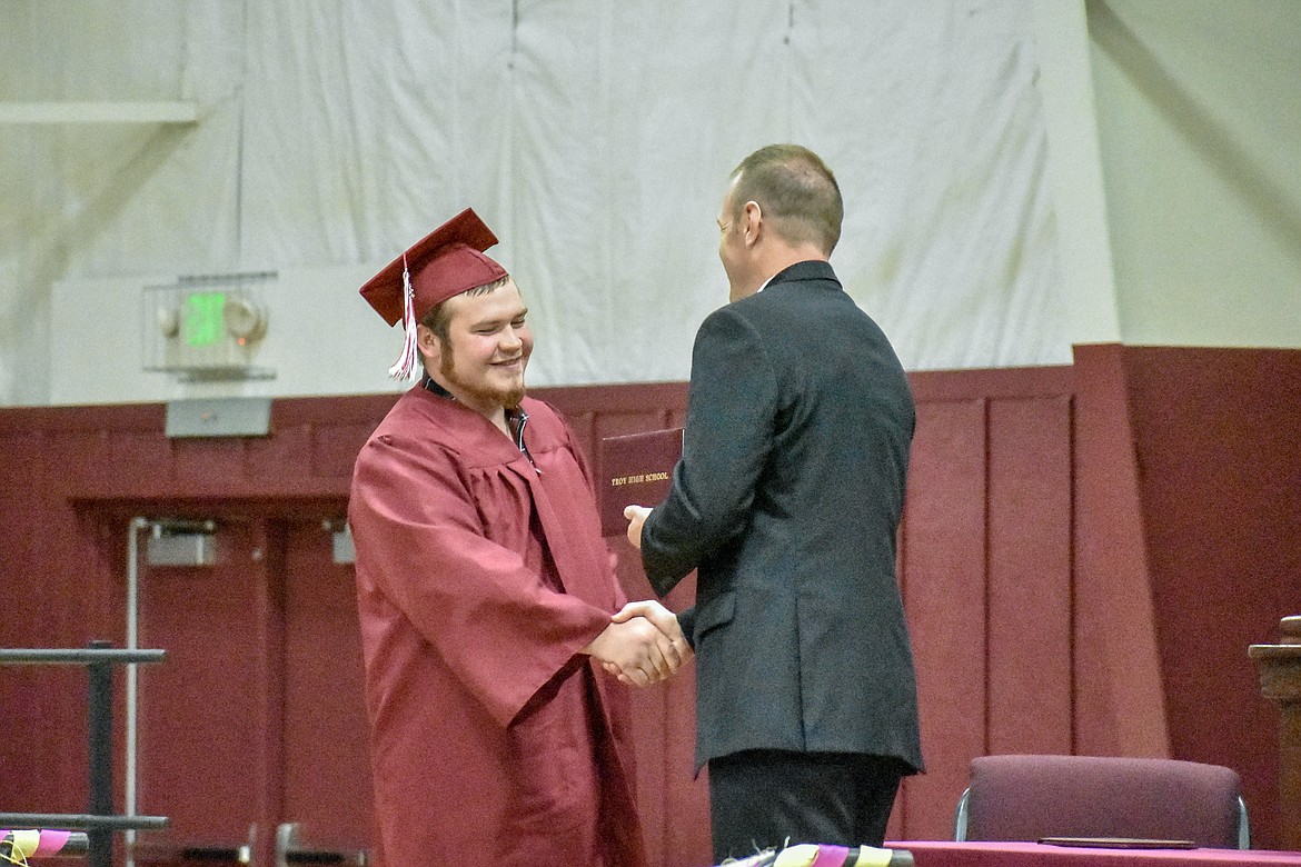 Troy's Tyler Ekstedt receives his diploma at the Troy School Activity Center auditorium during graduation on Saturday, June 2, 2018. (Ben Kibbey/The Western News)
