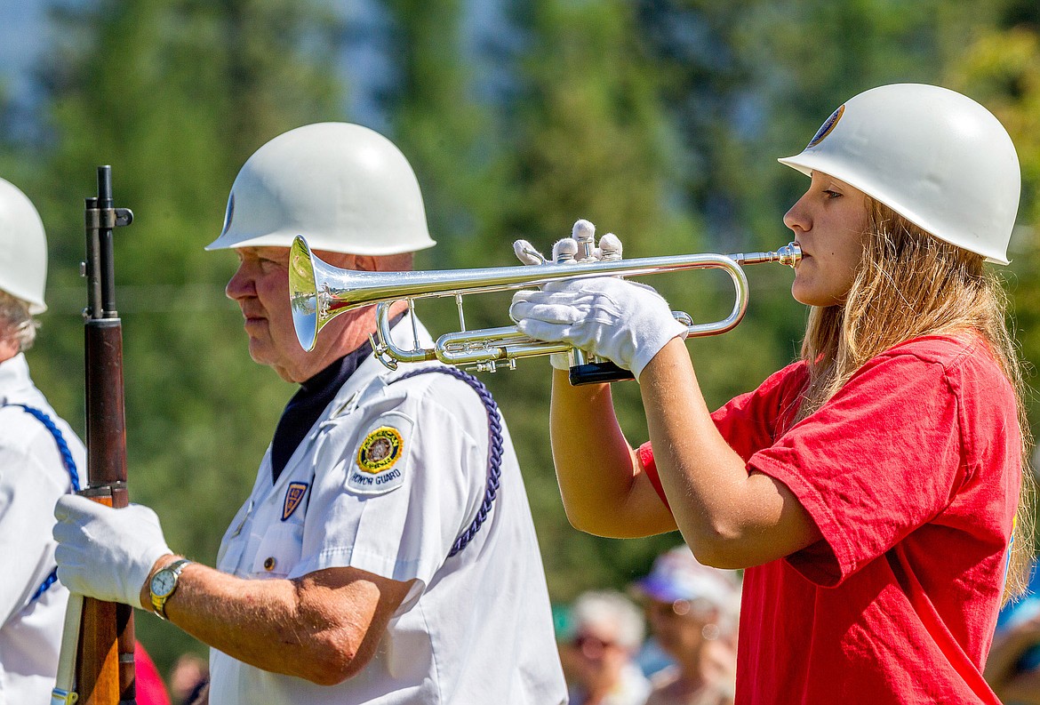 Libby High School student Cerria Swagger plays taps as Butch Urdahl of the American Legion Color Guard stands at attention during a Memorial Day service at Libby Cemetery on Monday, May 28, 2018. (John Blodgett/The Western News)