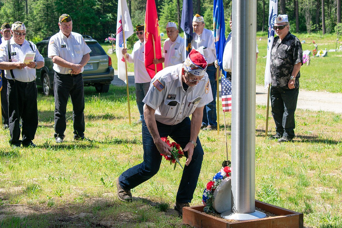 VFW John E. Freeman Post 5514 Senior Vice Commander Dan Savage places red flowers as a &#147;tribute of our devotion and everlasting remembrance.&#148; (Ben Kibbey/The Western News)