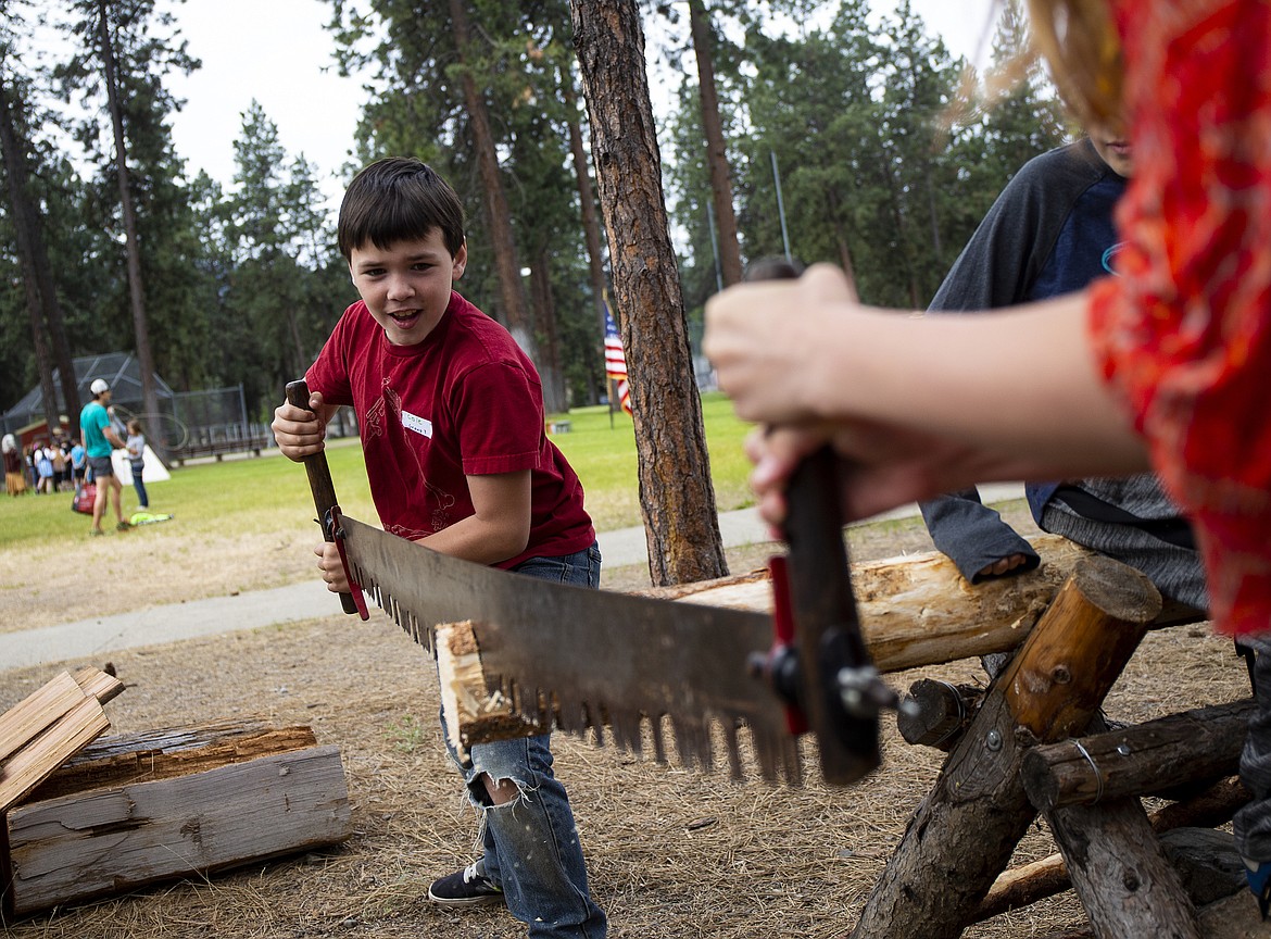Fourth-grader Cole Holley and Lowla Plummer cut wood at the lumber station during the Pat Triphahn Memorial Idaho History Rendezvous at Ponderosa Elementary in Post Falls. (LOREN BENOIT/Press)
