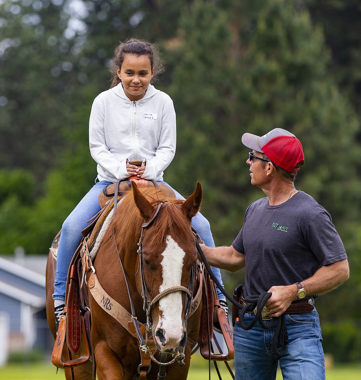 Dave Paul assists fourth-grader Laila Jones as she rides Red during the Pat Triphahn Memorial Idaho History Rendezvous Day at Ponderosa Elementary School in Post Falls on Thursday.