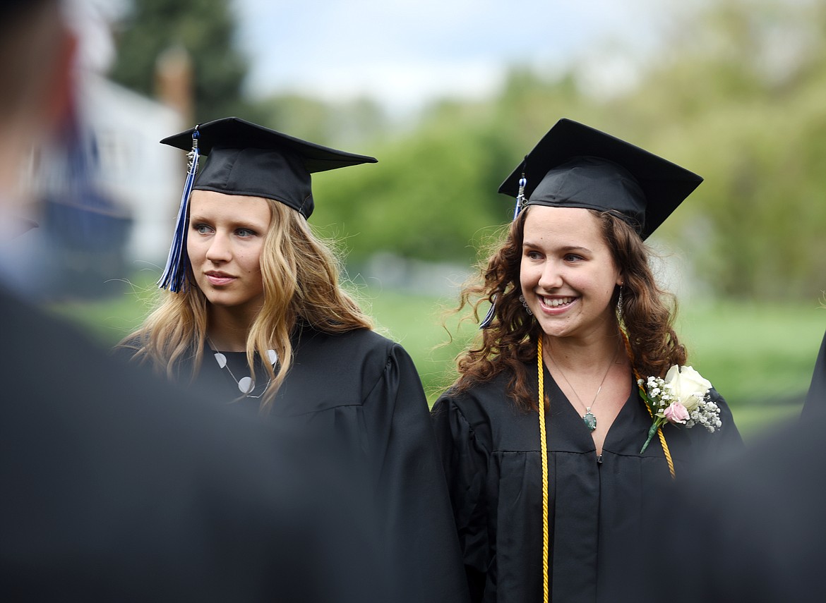 From left, Chloe Mathwig and McKenna Stahlberg smile as the seniors gather together outside the school prior to the commencement ceremony at Stillwater Christian School on Friday night, June 1.(Brenda Ahearn/Daily Inter Lake)